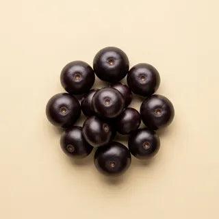 A small cluster of dark purple açaí berries