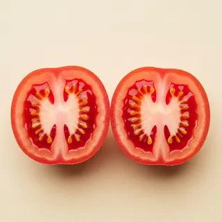 A halved ripe tomato - the natural source of lycopene - showing red flesh and yellow seeds