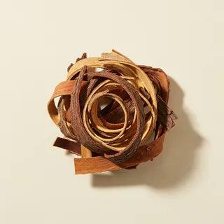 A coil of slippery elm bark, dried strips of ochre and walnut brown wound together